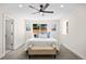 Well-lit bedroom features a ceiling fan, a large window, and a comfortable upholstered bench at 4645 E Florida Ave, Denver, CO 80222