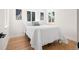 Bright bedroom with hardwood floors, a cozy bed with white linens, and well-lit windows at 4645 E Florida Ave, Denver, CO 80222