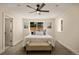 Well-lit bedroom features a ceiling fan, a large window, and a comfortable upholstered bench at 4645 E Florida Ave, Denver, CO 80222