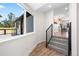 Bright entryway showcasing a staircase with stylish black railings and view of outdoor porch at 4645 E Florida Ave, Denver, CO 80222