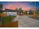 Home exterior with a long driveway and a beautiful sunset sky at 4645 E Florida Ave, Denver, CO 80222