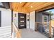Inviting front porch featuring a modern design with wood accents, stylish lighting, and a black front door at 4645 E Florida Ave, Denver, CO 80222