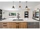 Modern kitchen features a large island with a breakfast bar, stainless steel appliances, and pendant lighting at 4645 E Florida Ave, Denver, CO 80222