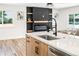 Bright kitchen features an island with breakfast bar, a modern faucet, and a fireplace at 4645 E Florida Ave, Denver, CO 80222