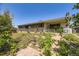 View of a brick ranch style house and backyard with overgrown vegetation and a brick patio area at 661 S Paris St, Aurora, CO 80012