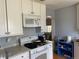 Bright kitchen features white cabinets, appliances, and granite countertops at 75 Pierce St, Lakewood, CO 80226