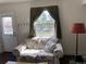 Cozy living room with floral sofa and a large window providing ample natural light at 75 Pierce St, Lakewood, CO 80226