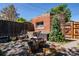 Cozy backyard featuring a brick structure, mature trees, and a shaded seating area with charming details at 433 Fox St, Denver, CO 80204