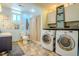 Well-lit bathroom with a double sink, tub, and modern washer and dryer for added convenience and functionality at 433 Fox St, Denver, CO 80204