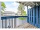 Balcony with blue wood railing and a view of neighborhood buildings and large trees at 1301 S Cathay Ct # 104, Aurora, CO 80017