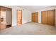 Spacious bedroom with neutral carpet, showing two closets and entrance to a bathroom and open to the living room at 1301 S Cathay Ct # 104, Aurora, CO 80017
