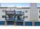 Townhouse exterior featuring private decks, blue trim, and matching garage doors at 1301 S Cathay Ct # 104, Aurora, CO 80017