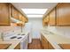 Compact kitchen with white appliances, wooden cabinets, and laminate countertops at 1301 S Cathay Ct # 104, Aurora, CO 80017