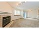 Carpeted living room featuring a fireplace, shuttered windows, and patio access at 1301 S Cathay Ct # 104, Aurora, CO 80017