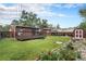 Expansive backyard featuring a deck, lush lawn, garden beds, and a storage shed at 7644 Wyandot St, Denver, CO 80221