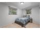 Comfortable bedroom with a cozy bed, two windows, and natural light at 7644 Wyandot St, Denver, CO 80221