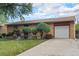 Brick home with a well-manicured lawn, custom landscaping, and attached garage at 7644 Wyandot St, Denver, CO 80221
