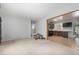 Spacious living room with an open layout into kitchen and neutral walls with plush carpet at 7644 Wyandot St, Denver, CO 80221