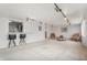 Bright living room with neutral carpet, track lighting, and open bar to the kitchen at 7644 Wyandot St, Denver, CO 80221