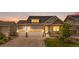 Charming two-story home at sunset featuring a three-car garage and stone accents at 5597 Pinto Valley St, Parker, CO 80134