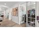 Hallway with wood floors leads to a study with French doors, artwork, and neutral paint at 5597 Pinto Valley St, Parker, CO 80134