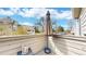 View of outdoor balcony area with shade umbrella, small wooden table, and lush green scenery at 3600 S Pierce St # 5-202, Denver, CO 80235