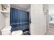 Bathroom featuring patterned shower curtain, white toilet, and view to bedroom at 3600 S Pierce St # 5-202, Denver, CO 80235