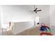 Bonus room with baby gate at stairwell, ceiling fan, and play space at 3600 S Pierce St # 5-202, Denver, CO 80235