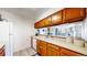 Functional kitchen with wooden cabinetry offering a view into the living room at 3600 S Pierce St # 5-202, Denver, CO 80235