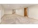Large basement space with wood trim, neutral carpet and a paneled door at 9346 Lark Sparrow Dr, Highlands Ranch, CO 80126