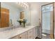 Bathroom with double sinks, marble countertop, and a view of the tub and shower at 9346 Lark Sparrow Dr, Highlands Ranch, CO 80126