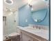 The bathroom features a walk-in shower, a marble vanity with a framed oval mirror, and blue walls at 9346 Lark Sparrow Dr, Highlands Ranch, CO 80126