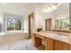 A vanity area with a sink and a view of a large soaking tub next to a backyard-facing window at 9346 Lark Sparrow Dr, Highlands Ranch, CO 80126