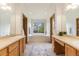 Bright bathroom with double vanities, soaking tub, and a large window with backyard views at 9346 Lark Sparrow Dr, Highlands Ranch, CO 80126