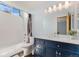 Modern bathroom featuring a dark blue vanity, white countertop, and a tiled shower and bathtub at 9346 Lark Sparrow Dr, Highlands Ranch, CO 80126