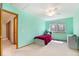 Bright teal bedroom with a view of the hallway, a bed, two windows, and a ceiling fan at 9346 Lark Sparrow Dr, Highlands Ranch, CO 80126