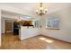 Open-concept dining room showcases the light wood floors and modern chandelier at 9346 Lark Sparrow Dr, Highlands Ranch, CO 80126