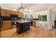 Open kitchen with granite counters, wood cabinets and black island with bar stool seating at 9346 Lark Sparrow Dr, Highlands Ranch, CO 80126