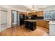 Open kitchen featuring an island with barstool seating, wood cabinets, and granite counters at 9346 Lark Sparrow Dr, Highlands Ranch, CO 80126