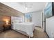 Bright bedroom featuring plush carpet, a window with blinds, a television, and wood accent wall at 13824 E Lehigh Ave # B, Aurora, CO 80014