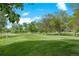 Lush green golf course view with mature trees under a sunny sky, offering a picturesque and tranquil setting at 13824 E Lehigh Ave # B, Aurora, CO 80014