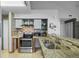 Modern kitchen featuring granite countertops, stainless steel appliances, and stylish tile backsplash at 13824 E Lehigh Ave # B, Aurora, CO 80014