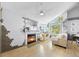 Bright living room featuring a fireplace, television, and large windows at 13824 E Lehigh Ave # B, Aurora, CO 80014