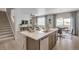 Open-concept floor plan with large island between kitchen, dining area, and living room at 3285 Belleville Ridge Rd, Elizabeth, CO 80107