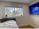 Well-lit bedroom with a plush daybed, featuring a large window offering exterior views at 8950 W 26Th, Lakewood, CO 80215