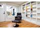 Inviting living space with a comfortable chair, ottoman, hardwood floors, and built-in bookshelves at 8950 W 26Th, Lakewood, CO 80215