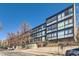 Modern building with multiple units and large windows offering natural light and views, situated on a tree-lined street at 1050 N Corona St # 308, Denver, CO 80218