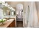 Bathroom with a wood vanity, white towels, and an archway to the bedroom at 341 Granby Way # A, Aurora, CO 80011