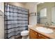 Bright bathroom featuring a vanity with storage, toilet, and stylish blue and white striped shower curtain at 341 Granby Way # A, Aurora, CO 80011