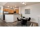Dining area featuring a modern table setting adjacent to a functional kitchen with wooden cabinets at 341 Granby Way # A, Aurora, CO 80011